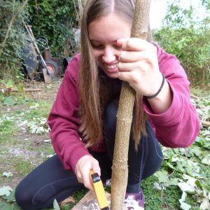 A teenage girl makes a pole for the geodome